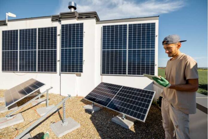 Technician with a tablet on a rooftop with solar power station